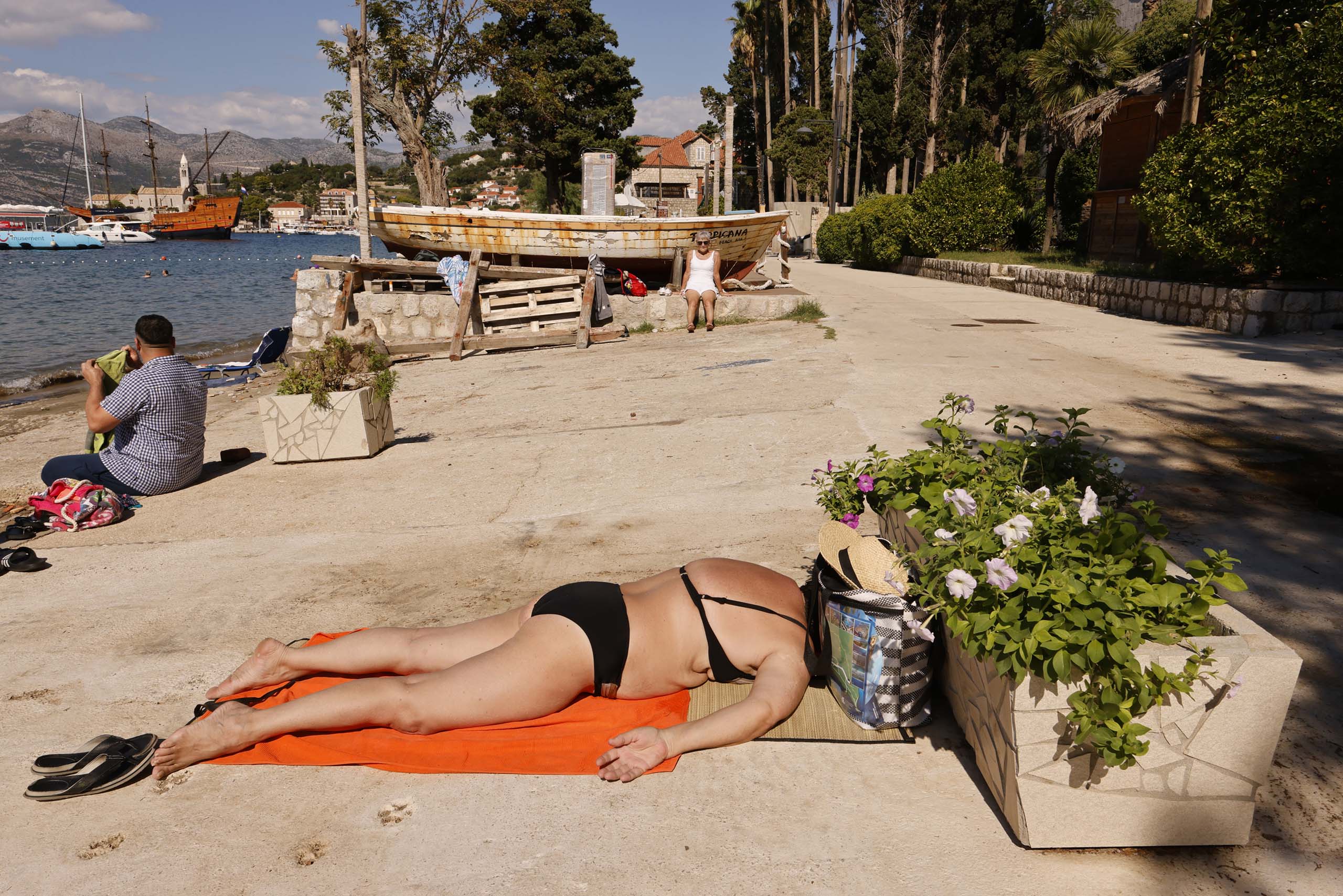 Photo of woman sunbathing on beach by Leslie Fratkin